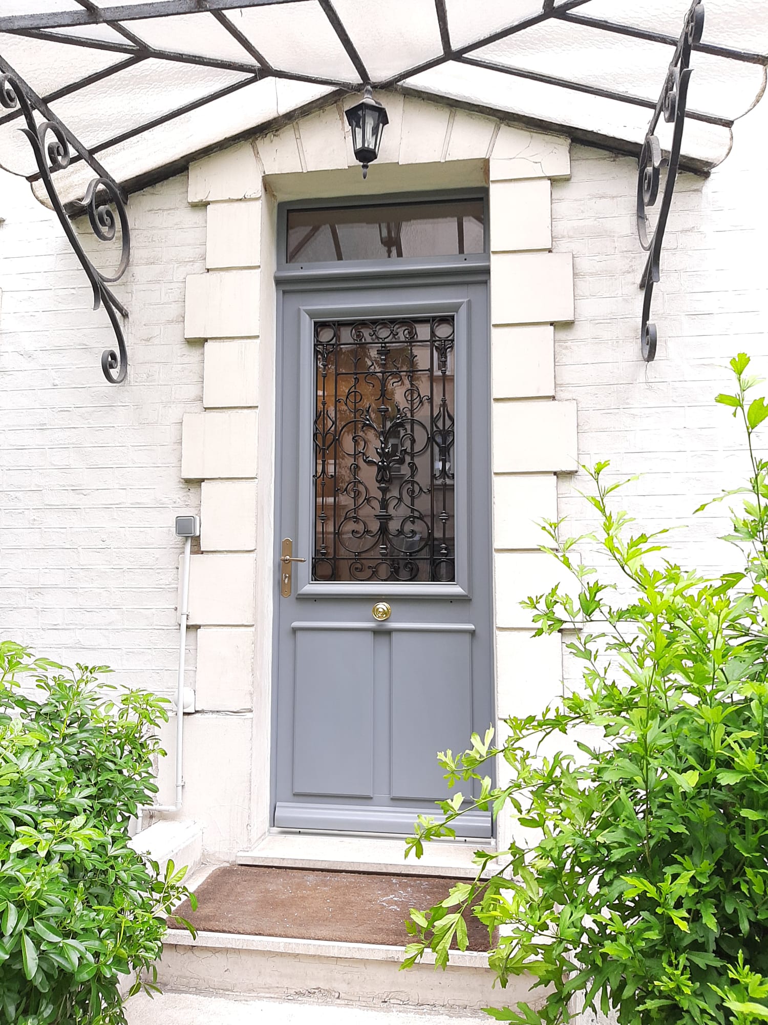 Porte d’entrée grise avec vitrage décoratif